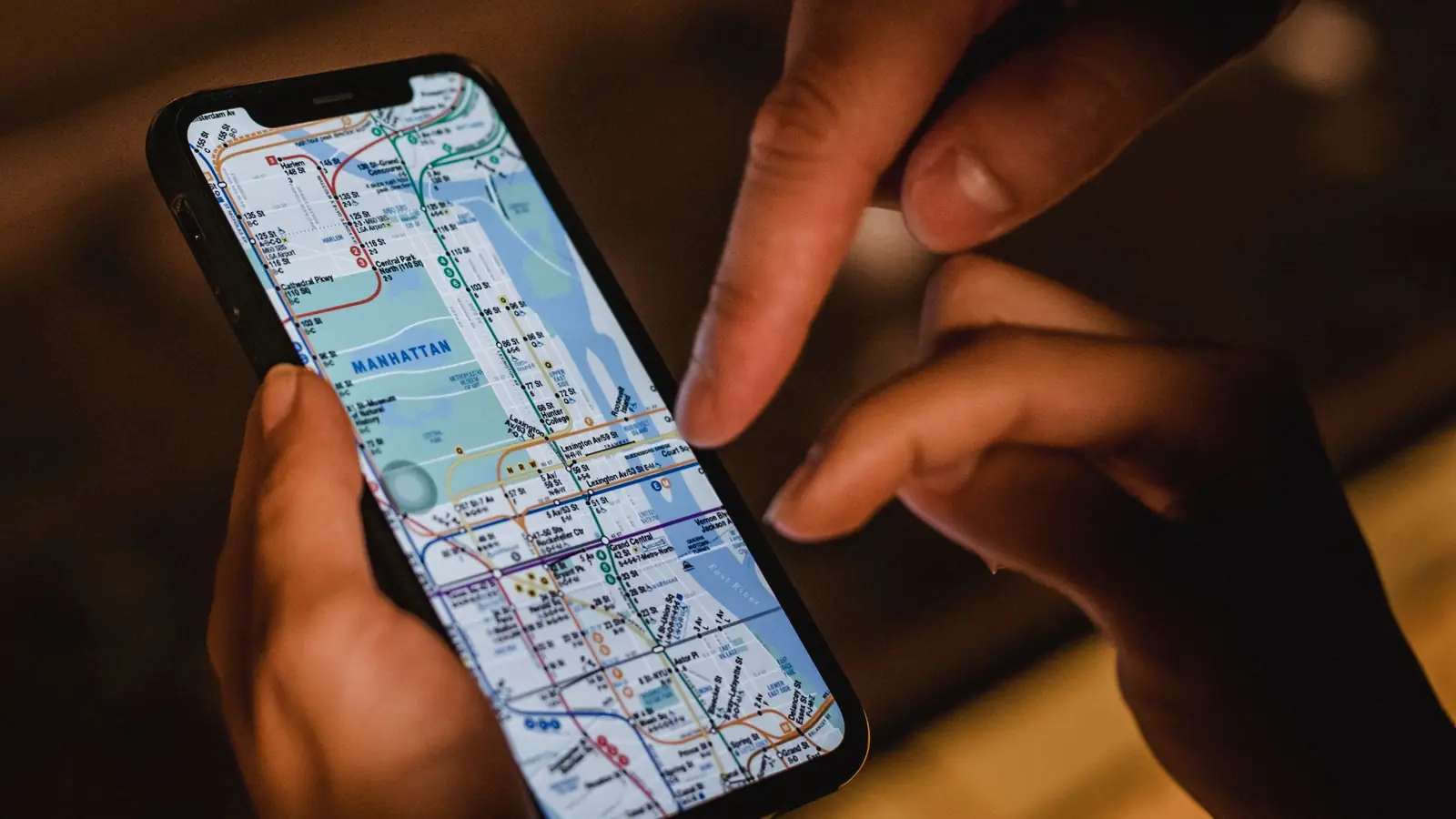 Mâini care folosesc o hartă pe ecranul unui telefon